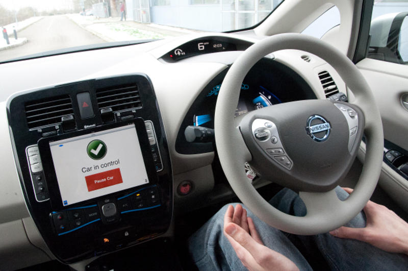 Inside of a car, showing steering wheel and screen